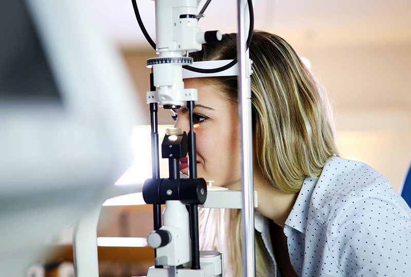 a female patients eye test on slit lamp